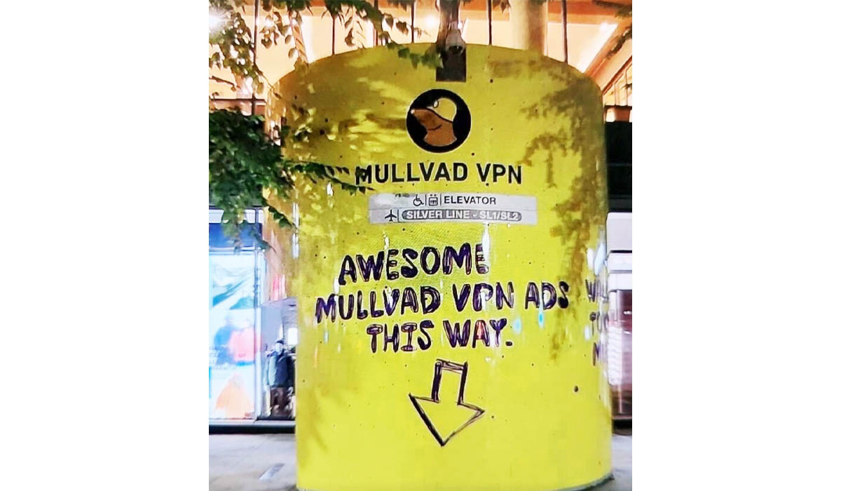 Yellow pillar with Mullvad VPN logo and text: MULLVAD VPN, ELEVATOR SILVER LINE - SL1/SL2, AWESOME MULLVAD VPN ADS THIS WAY, and a down arrow.